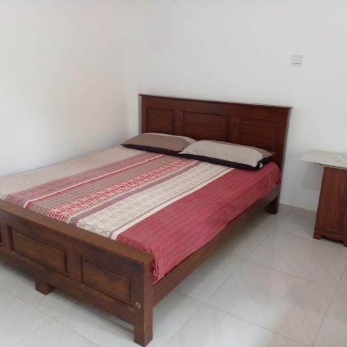 a bedroom with a bed with a wooden frame at Villa in Yakkala, Gampaha 