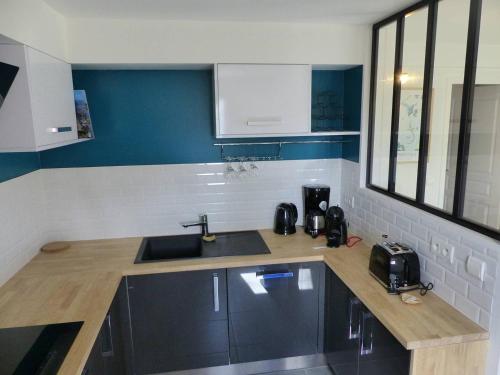une cuisine avec un évier et un plan de travail dans l'établissement Residence AMARINE Appartement avec terrasse et piscine collective chauffée, à Capbreton