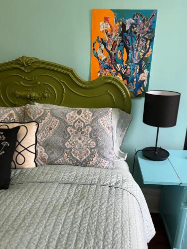 a bed with a green headboard and a table with a lamp at Soul Food in New York