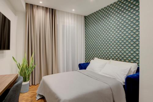 una camera con letto e parete verde di Well Suites - Piazza dei Martiri a Napoli