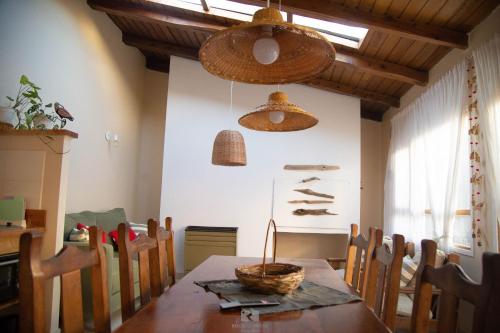 エスケルにあるCasa Jardin Adesmiaのダイニングルーム(テーブル付)、壁にカゴが付いています。