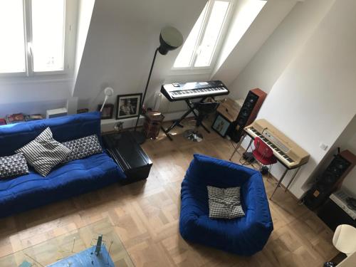 - un salon avec un canapé bleu et un clavier dans l'établissement Au cœur de saint Germain des pres, à Paris