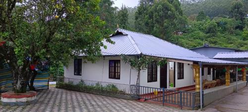 a white house with a metal roof at NAVANEETH HOMESTAY in Devikolam