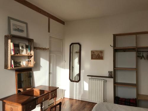 ein Wohnzimmer mit einem Spiegel und einem Tisch in der Unterkunft chambre double chez Catherine et Jean-Luc en Bretagne in Audierne