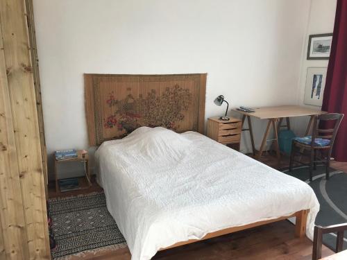 Schlafzimmer mit einem Bett, einem Tisch und einem Schreibtisch in der Unterkunft chambre double chez Catherine et Jean-Luc en Bretagne in Audierne