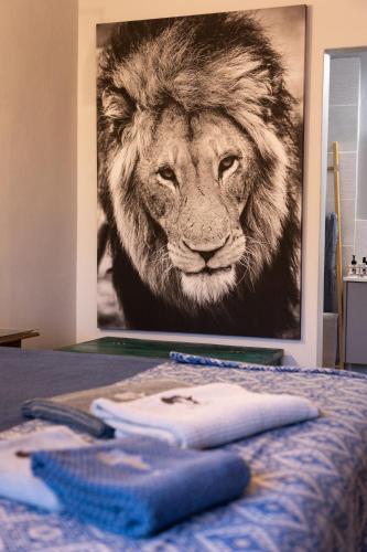 a painting of a lion on a wall in a bedroom at Africa House in Hoedspruit