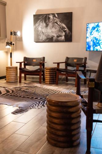 a room with chairs and a picture of a lion at Africa House in Hoedspruit