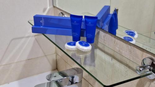 een glazen plank in een badkamer met tandenborstels bij ALJAWHARA INN HOTEL in Seeb