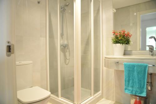 uma casa de banho com um chuveiro, um WC e um lavatório. em Estepona (in het hartje van het stadje) em Estepona