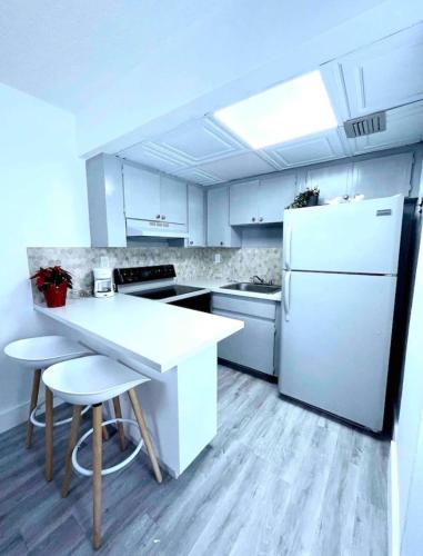 a kitchen with a white refrigerator and a table and chairs at Miami International Airport 1 in Miami