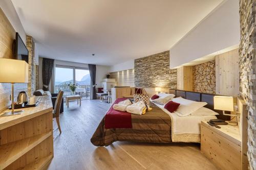 a bedroom with a large bed and a stone wall at Alpenresort Belvedere Wellness & Beauty in Molveno