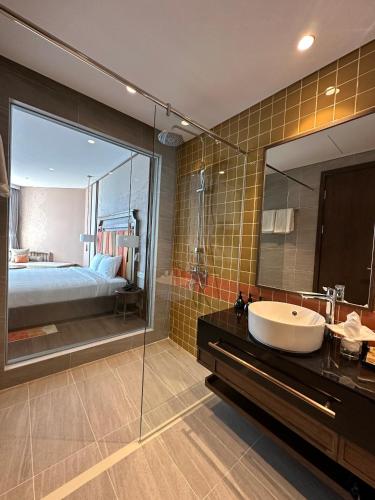 a bathroom with a sink and a large mirror at Apec Mandala Mũi Né - Phan Thiết in Phan Thiet