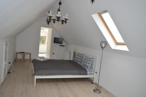 a white bedroom with a bed in a attic at Casa Aris Lepsa Vrancea in Lepşa