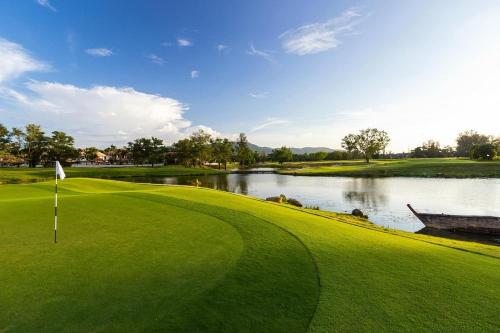 uma vista para um campo de golfe com um lago em Kamala pool Villa em Praia de Kamala
