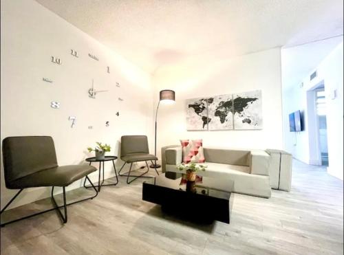 a living room with a white couch and chairs at Miami International Airport 1 in Miami