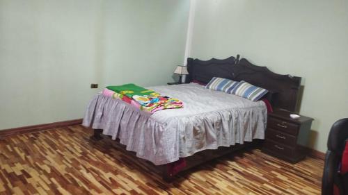 um quarto com uma cama e uma cabeceira em madeira em Habitación Matrimonial Oruro Carnaval em Oruro