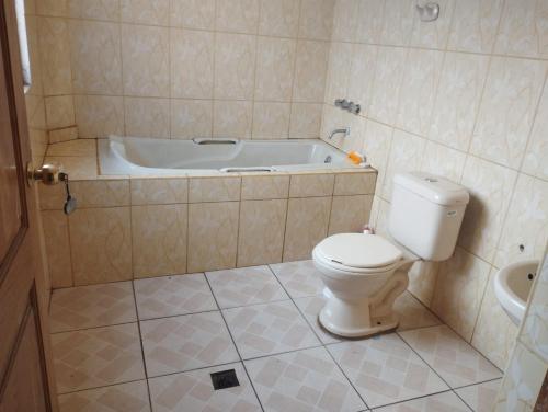 uma casa de banho com um WC e uma banheira em Habitación Matrimonial Oruro Carnaval em Oruro