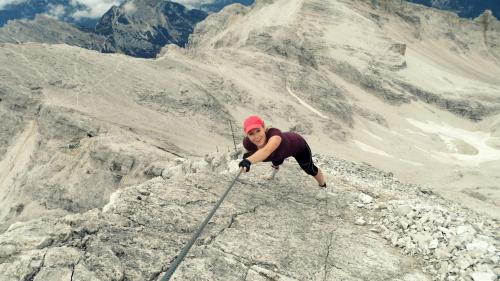 a person is climbing up a rocky mountain at Pension Panorama in San Lorenzo di Sebato