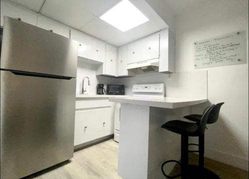 a kitchen with a stainless steel refrigerator and a stool at Miami International Airport 1 in Miami