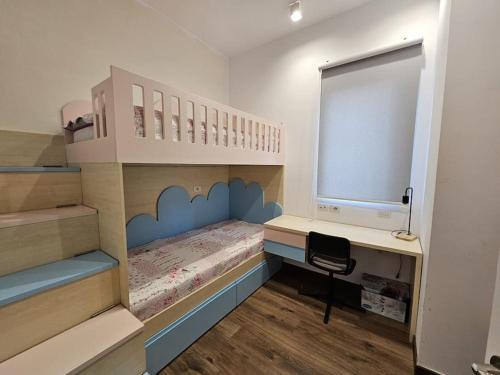 - une petite chambre avec des lits superposés et un bureau dans l'établissement Deluxe Flat with garden_Tirana, à Tirana