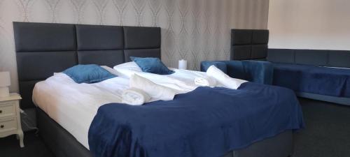 sypialnia z 2 łóżkami z niebieską pościelą i poduszkami w obiekcie Harmonica Studio w Nowym Sączu