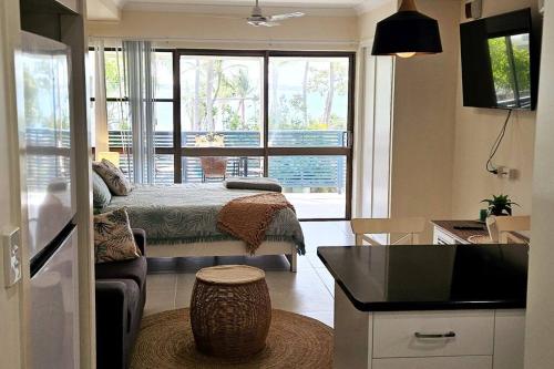 pequeña sala de estar con cama y cocina en WhitsunStays - Le Beach Shack, en Mackay