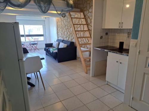 une cuisine et un salon avec un canapé et une table dans l'établissement Studio Mezzanine pour 4 à Marseillan avec Parking Privé, TV et Cuisine Équipée - FR-1-326-783, à Marseillan