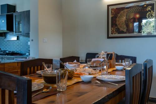 a wooden table with plates of food on it at SaffronStays Wood Sparrow in Bhīm Tāl