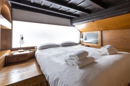 ein Schlafzimmer mit einem großen weißen Bett mit Handtüchern darauf in der Unterkunft Maison Bilot in Rom
