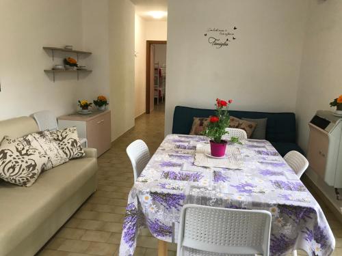 a living room with a table and a couch at Le Villette di Villa Paola in Loano