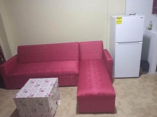 ein rosafarbenes Sofa im Wohnzimmer mit Kühlschrank in der Unterkunft Kapowlito Real Estate Casa Grootblijdenshoopweg in Paramaribo