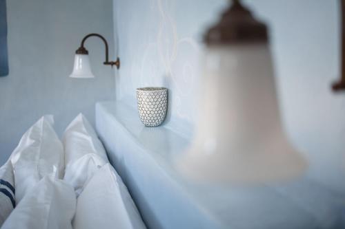 a cup sitting on a table next to a bed at ES CUCONS RURAL HOTEL in San Antonio