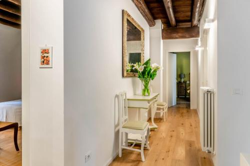 a room with a table with chairs and a vase of flowers at Agriturismo Il Leone della Torre in Contrada Ronchiel