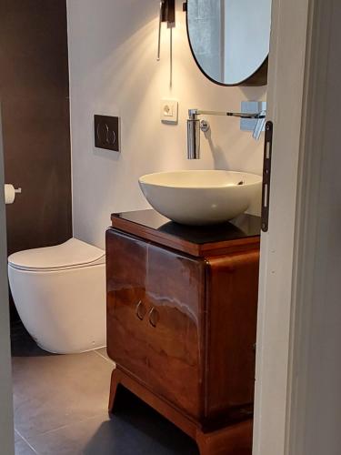 La salle de bains est pourvue d'un lavabo et d'un miroir sur une commode. dans l'établissement LESS IS MORE, à Tuscania
