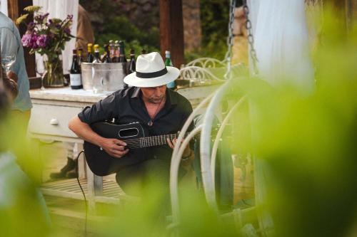 a man in a white hat playing a guitar at ES CUCONS RURAL HOTEL in San Antonio
