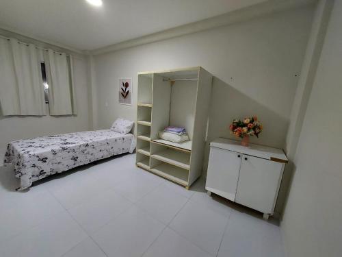 Un pequeño dormitorio con una cama y un pequeño armario en Residencial Atalaia Sul, en Aracaju