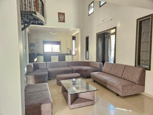 a living room with a couch and a table at Seven Villa with Swimming pool in Panchgani