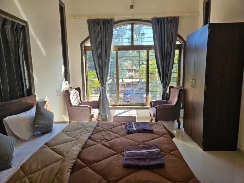 a bedroom with a large bed and a large window at Seven Villa with Swimming pool in Panchgani