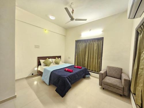 a bedroom with a bed and a chair at Seven Villa with Swimming pool in Panchgani