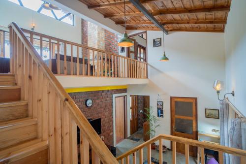 a room with a staircase and a brick fireplace at SaffronStays Wood Sparrow in Bhīm Tāl