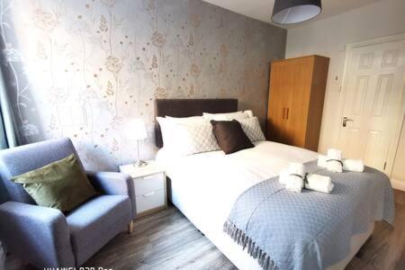 um quarto com uma cama e uma cadeira azul em Cosy 1bed apartment with nice patio and fast WIFI F1 em Dublin