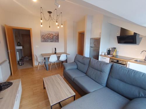 un soggiorno con un divano blu e un tavolo di Apartamento a estrenar en A Pobra do Caramiñal a A Pobra do Caramiñal