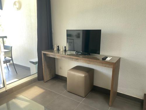 Habitación con escritorio y TV. en Duplex du Golfeur, en Saint-François