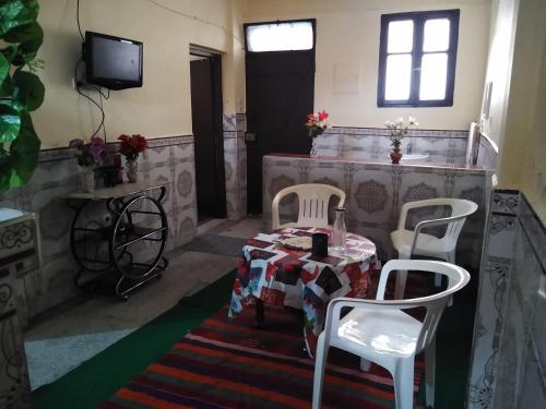 Cette chambre dispose d'une table, de deux chaises et d'une télévision. dans l'établissement Casa Di Medina, à Tiznit
