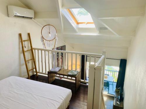 Un dormitorio con una cama y un balcón con ventana. en Duplex du Golfeur, en Saint-François