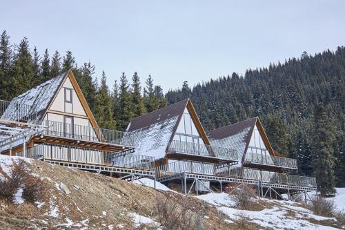 a house on top of a hill in the snow at Karakol Resort in Karakol