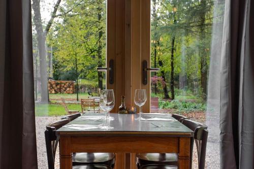 a table with wine glasses sitting on it in front of a window at Buitenplaats Petersburg in Arnhem