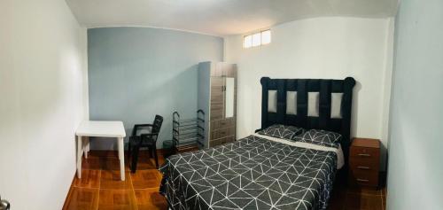 um quarto com uma cama, uma mesa e cadeiras em DEPARTAMENTO CON 3 DORMITORIOS em Huánuco