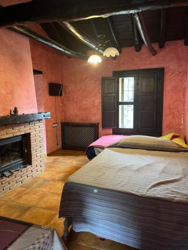 a bedroom with two beds and a fireplace at Apartamentos en Alfacar in Alfacar