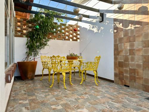einen gelben Tisch und Stühle auf einer Terrasse in der Unterkunft Habitación agradable in Comitán de Domínguez
